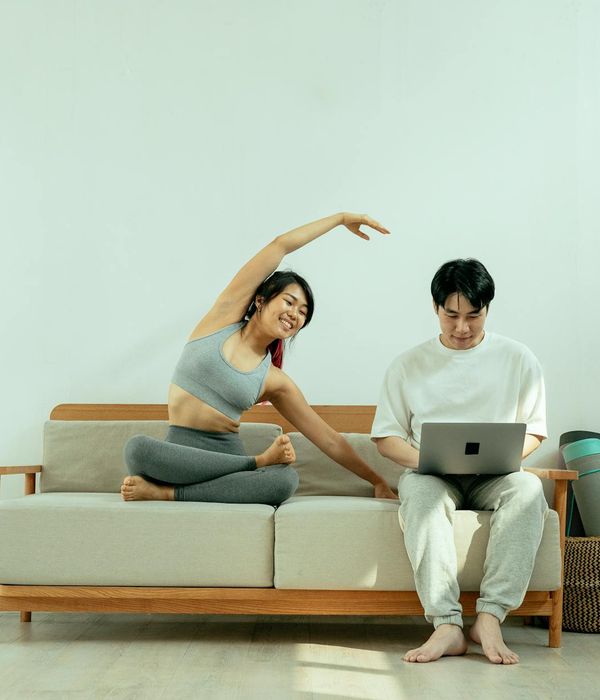 Woman in activewear smiling during a light workout at home.